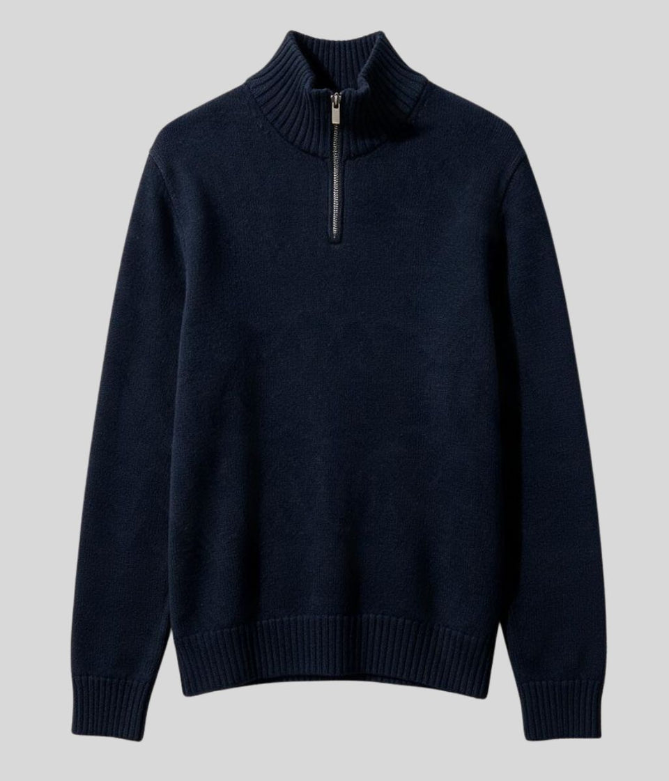 A dark navy blue knit quarter-zip sweater with a ribbed mock neck, cuffs, and hem, displayed against a solid light gray background.