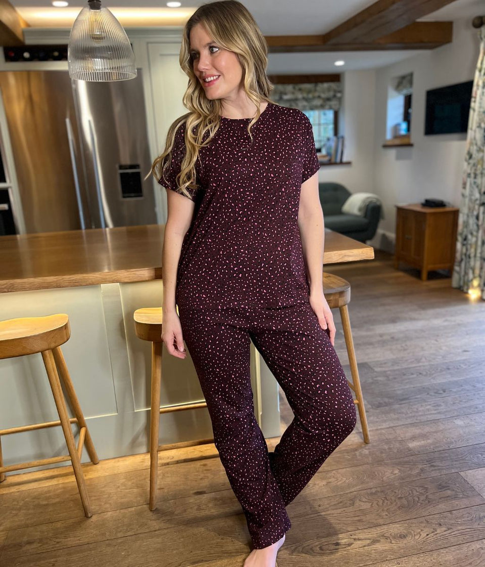 Woman in a maroon polka dot outfit standing in a kitchen.