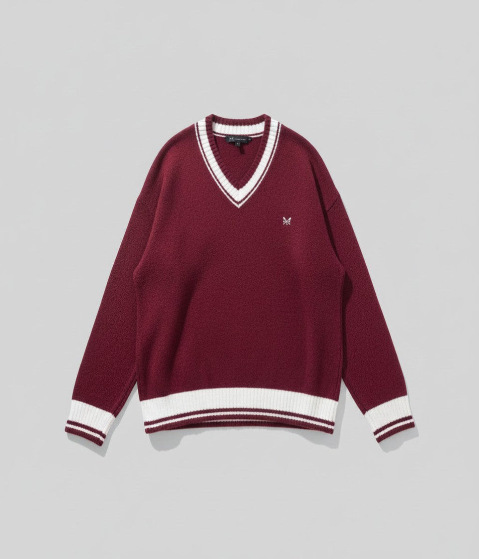 Maroon sweater with white trim on a gray background