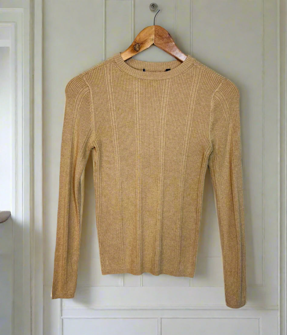 Brown ribbed sweater on a hanger against a white wall