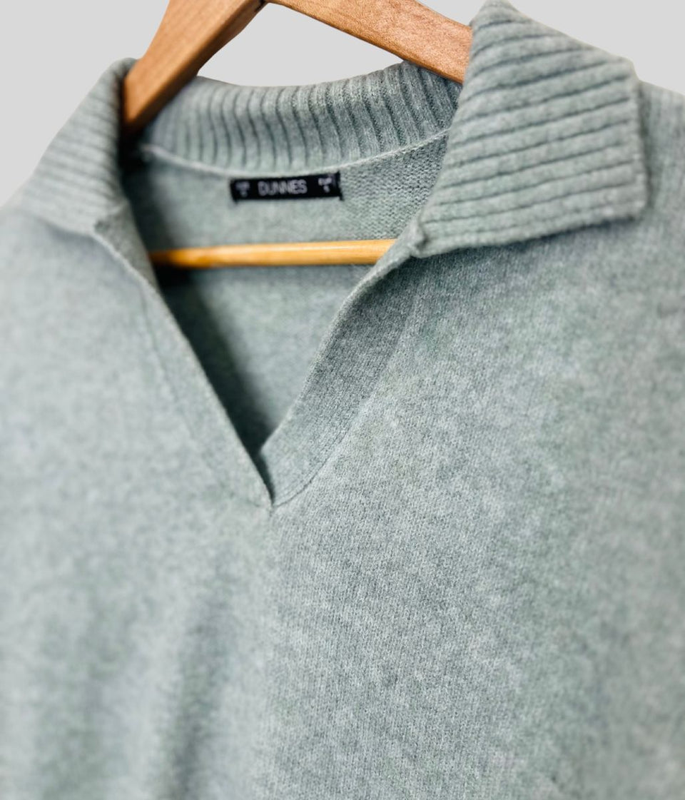 Gray sweater on a hanger with a blurred background