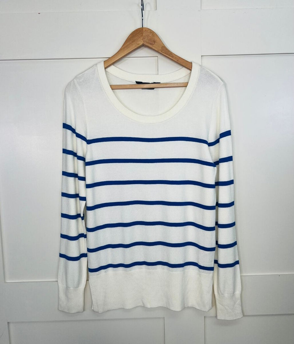 White sweater with blue stripes on a wooden hanger against a white background